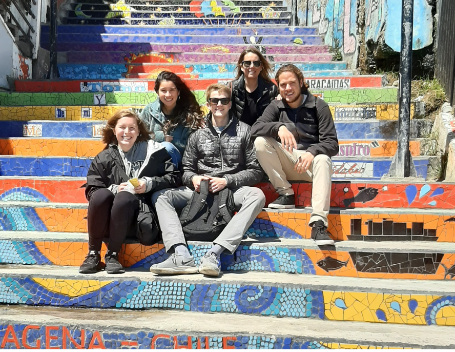 five students sitting on steps painted in various colors