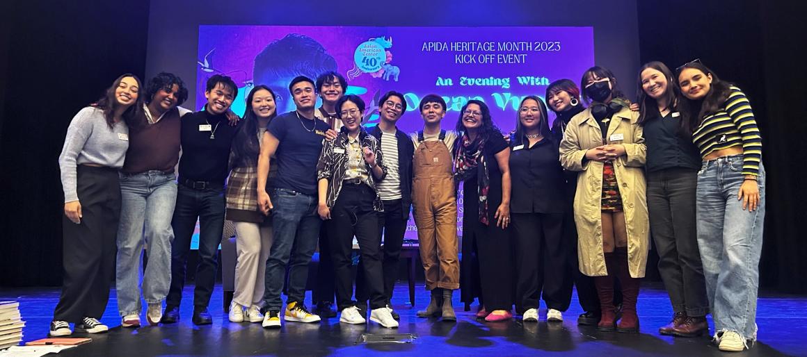 Group of students and staff standing on stage with writer Ocean Vuong