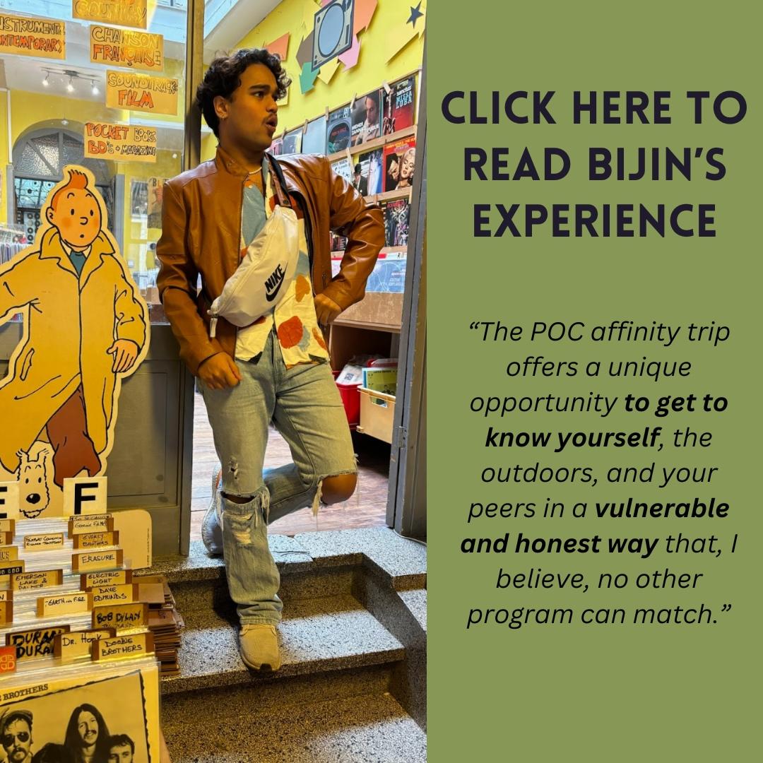 Image of TWO leader Bijin Basu standing in front of a storefront in jeans and leather jacket