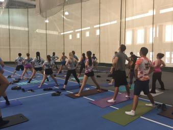Students participating in yoga class in gym