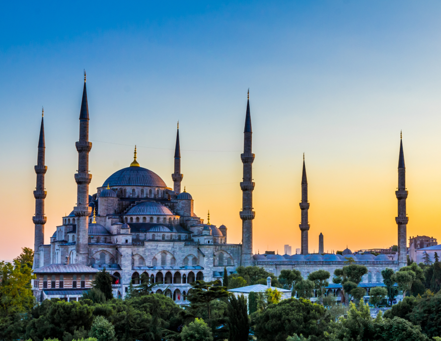 Large building with round dome and spires in Istanbul at sunset