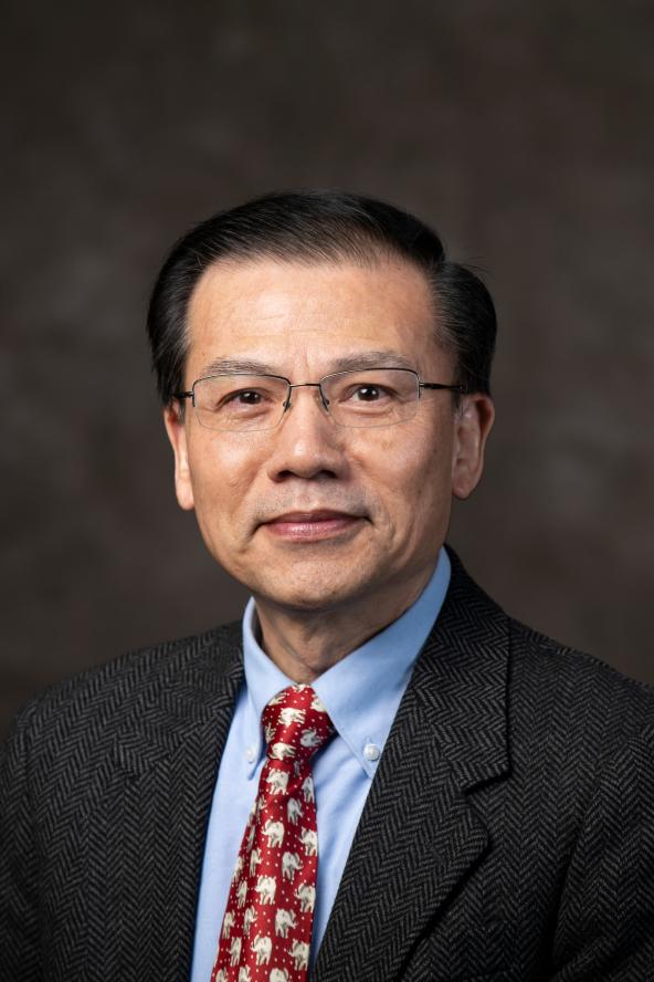 professional headshot of faculty member Mingquan Wang wearing a suit and tie