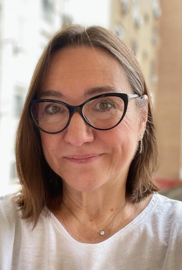 Headshot of Tufts in Madrid Director Susan Sanchez Casal wearing white shirt and glasses
