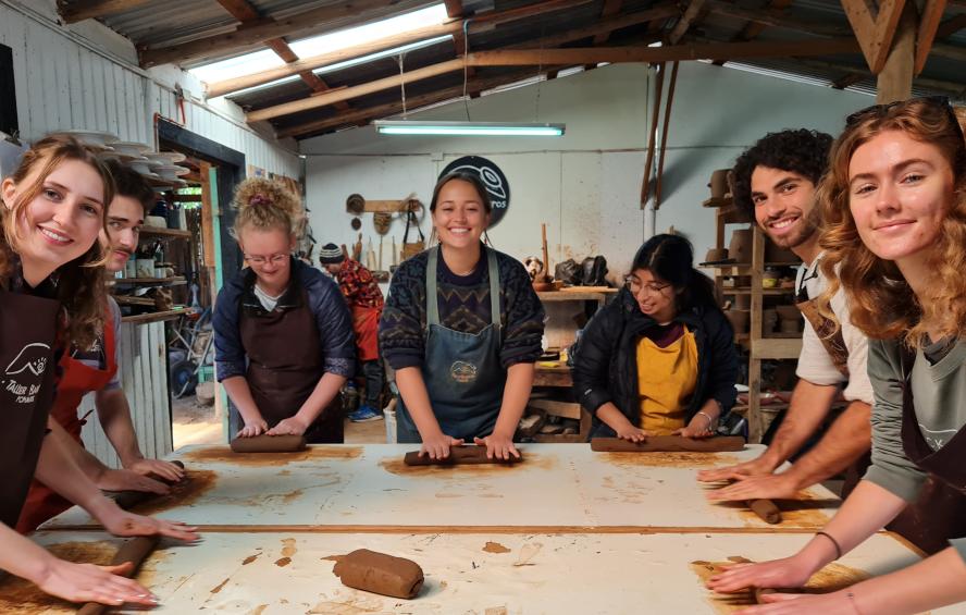 group of 7 students around a table in a pottery workshop, Tufts in Chile program, fall 2022
