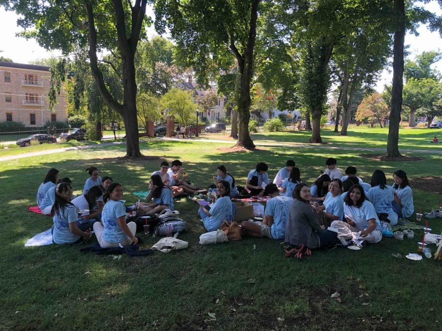 Students sitting on the campus green.