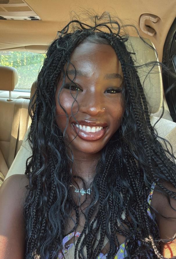 Image of Dafina in a car smiling brightly